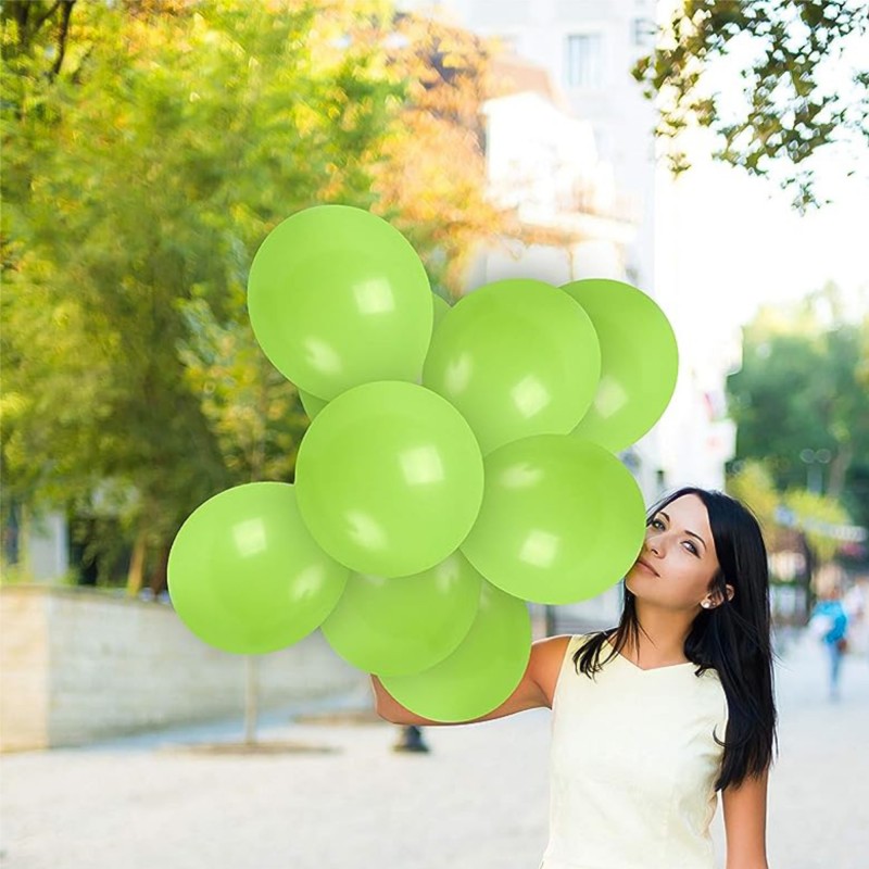 Flera gröna ballonger sväva mot en vit bakgrund, vilket ger en livlig och lekfull atmosfär.